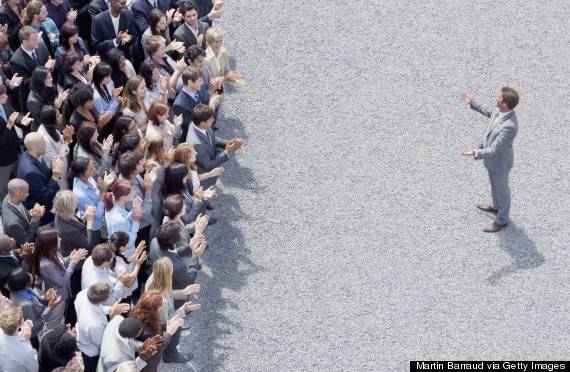 Businessman addressing clapping crowd